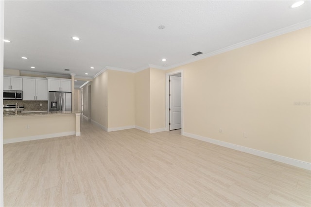 16357 SE 88th Ct, Summerfield, FL 34491 - unfurnished living room featuring recessed lighting, crown molding, light wood-type flooring, and baseboards