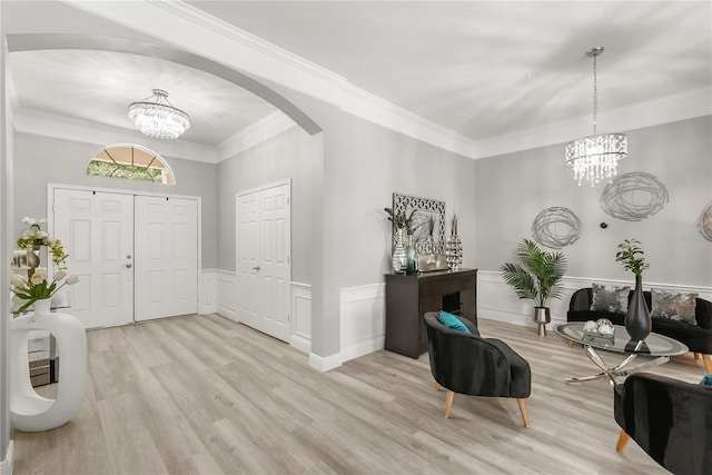 6426 Montclair Bluff Ln, Windermere, FL 34786 - foyer featuring a chandelier, arched walkways, light wood-type flooring, ornamental molding, and wainscoting