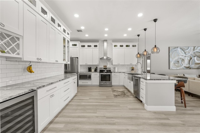 6426 Montclair Bluff Ln, Windermere, FL 34786 - kitchen featuring wine cooler, wall chimney range hood, stainless steel appliances, a breakfast bar, and a peninsula