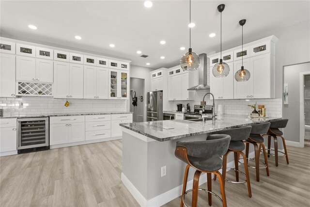 6426 Montclair Bluff Ln, Windermere, FL 34786 - kitchen featuring wine cooler, wall chimney exhaust hood, a peninsula, appliances with stainless steel finishes, and decorative backsplash