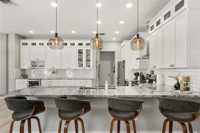 6426 Montclair Bluff Ln, Windermere, FL 34786 - kitchen featuring appliances with stainless steel finishes, decorative backsplash, a peninsula, a sink, and wine cooler