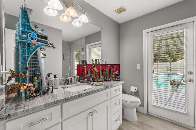 6426 Montclair Bluff Ln, Windermere, FL 34786 - bathroom with vanity, toilet, a stall shower, wood finished floors, and plenty of natural light