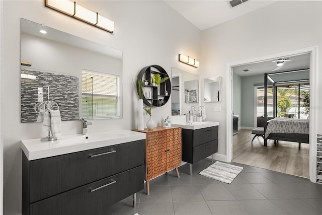 6426 Montclair Bluff Ln, Windermere, FL 34786 - ensuite bathroom with tile patterned flooring, two vanities, a towering ceiling, and baseboards