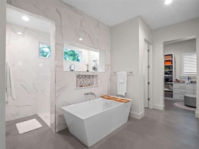 340 Lakeview Rd, Winter Garden, FL 34787 - bathroom with a soaking tub, a marble finish shower, a spacious closet, tile walls, and recessed lighting