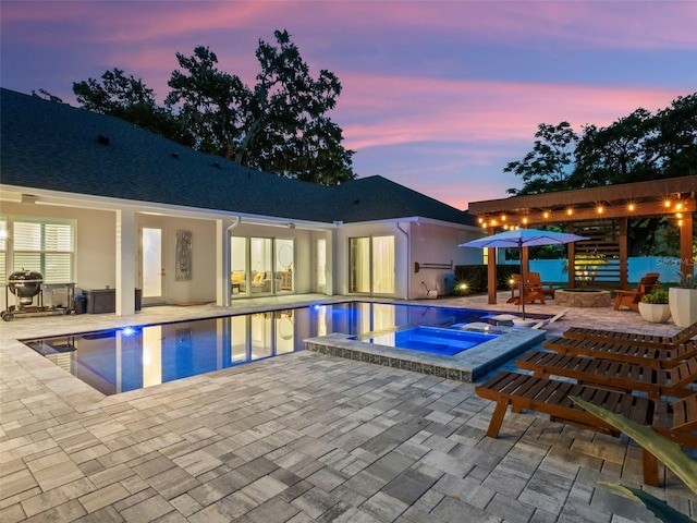340 Lakeview Rd, Winter Garden, FL 34787 - pool at dusk featuring a patio area, an outdoor fire pit, and a pool with connected hot tub