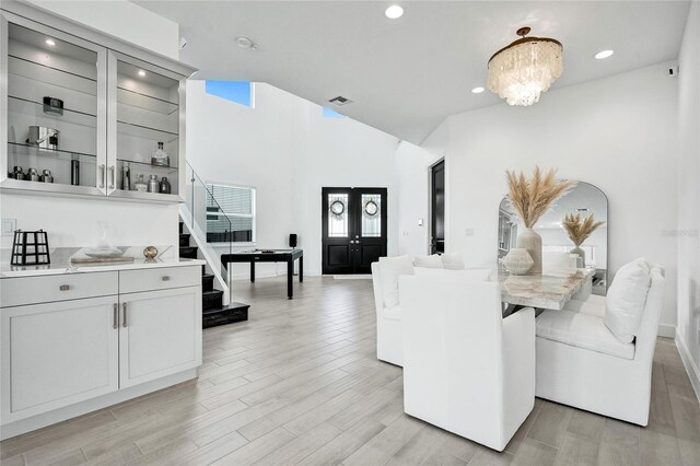 5609 Zestar Ln, Loxahatchee, FL 33470 - dining room featuring stairs, light wood-style floors, a chandelier, recessed lighting, and a high ceiling