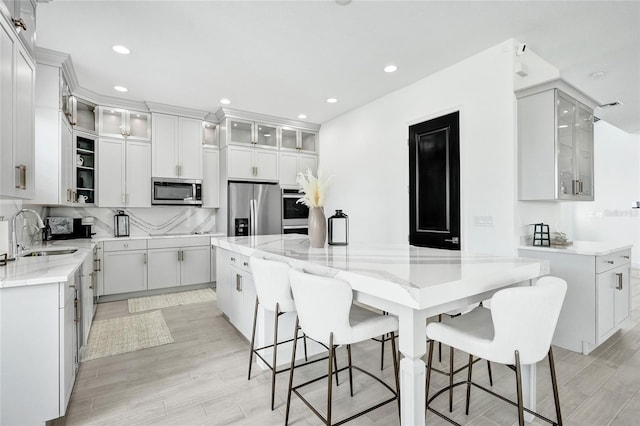 5609 Zestar Ln, Loxahatchee, FL 33470 - kitchen featuring a sink, stainless steel appliances, light stone countertops, light wood-style flooring, and recessed lighting