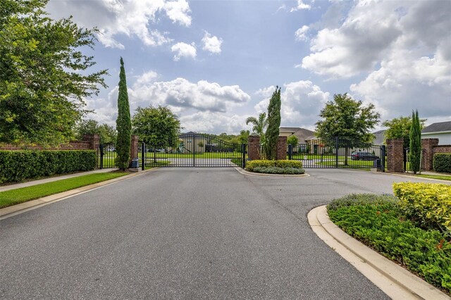 1113 Fieldstone Cir, Oviedo, FL 32765 - view of asphalt road with a gate, a gated entry, and curbs
