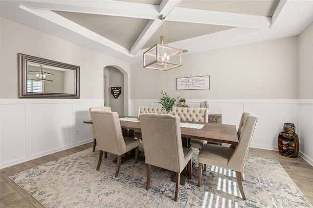 1113 Fieldstone Cir, Oviedo, FL 32765 - dining room with a chandelier, arched walkways, a wainscoted wall, beamed ceiling, and a decorative wall