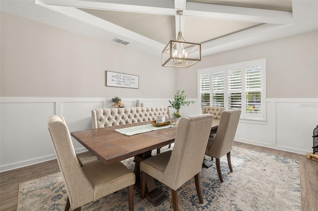 1113 Fieldstone Cir, Oviedo, FL 32765 - dining area with a chandelier, wainscoting, wood finished floors, a decorative wall, and beam ceiling