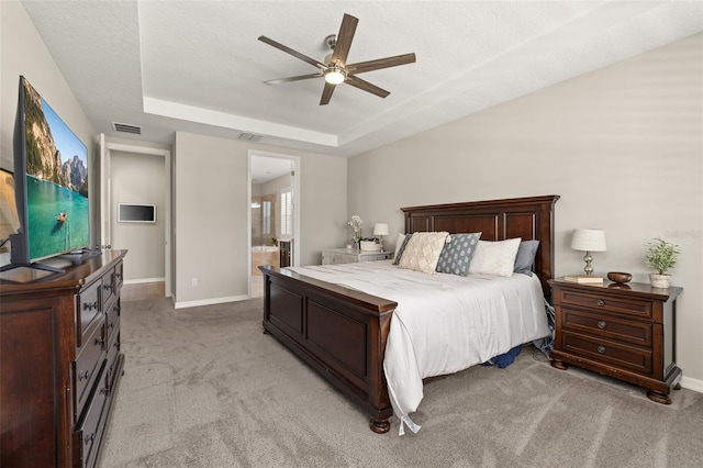 1113 Fieldstone Cir, Oviedo, FL 32765 - bedroom featuring a tray ceiling, light colored carpet, ceiling fan, and ensuite bath