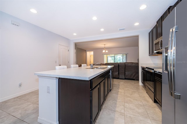 110 Claire Ln, Davenport, FL 33837 - kitchen with appliances with stainless steel finishes, a center island with sink, a sink, light countertops, and light tile patterned floors