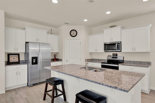 kitchen with stainless steel appliances, a sink, white cabinetry, and recessed lighting