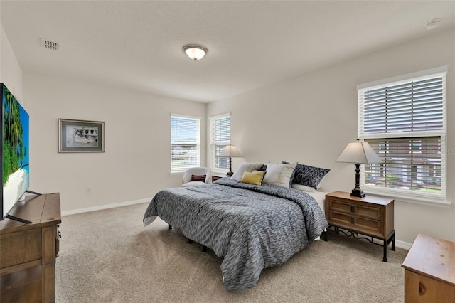 bedroom with light carpet and baseboards