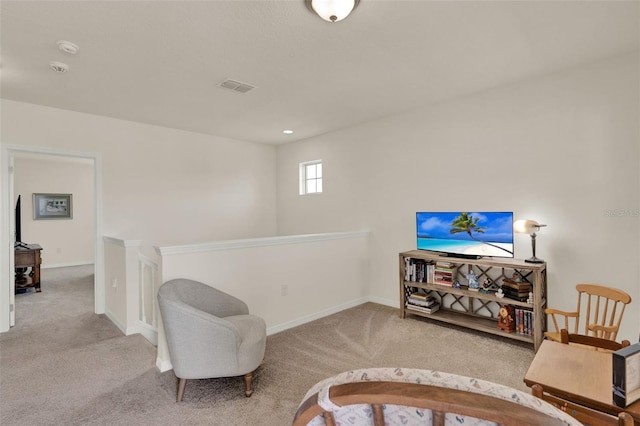 sitting room featuring carpet floors, an upstairs landing, and baseboards