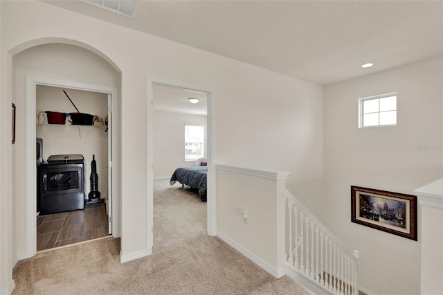 corridor featuring light carpet, an upstairs landing, healthy amount of natural light, baseboards, and recessed lighting