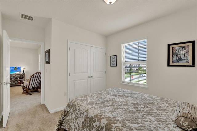 bedroom with light carpet, a closet, and baseboards