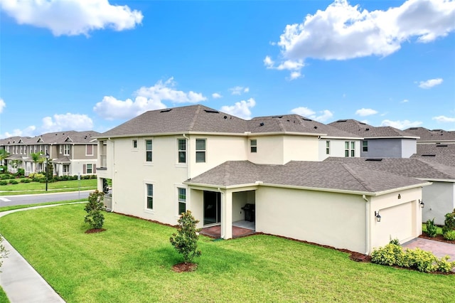 back of house with a residential view, a yard, an attached garage, stucco siding, and driveway
