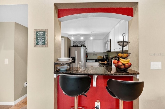 1321 Arbor Vista Loop Unit 301, Lake Mary, FL 32746 - kitchen with stainless steel appliances, white cabinetry, a peninsula, a kitchen breakfast bar, and arched walkways