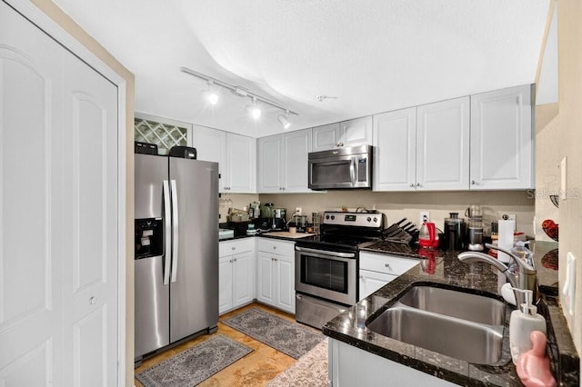 1321 Arbor Vista Loop Unit 301, Lake Mary, FL 32746 - kitchen featuring appliances with stainless steel finishes, white cabinets, dark stone countertops, and track lighting