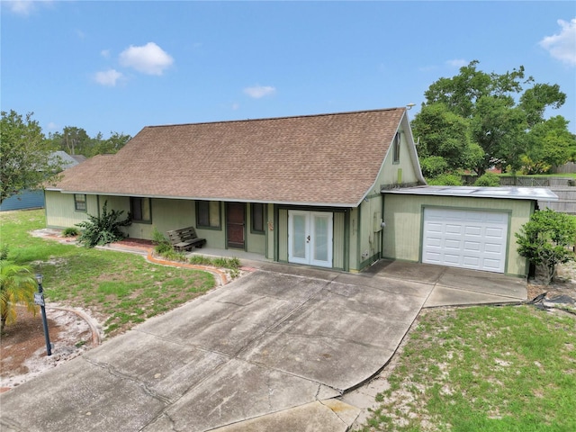40533 E 8th Ave, Umatilla, FL 32784 - view of front of house with french doors, driveway, a shingled roof, a garage, and a front lawn