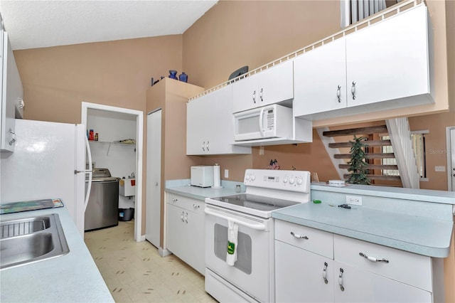 40533 E 8th Ave, Umatilla, FL 32784 - kitchen featuring white appliances, washer / dryer, light floors, light countertops, and high vaulted ceiling