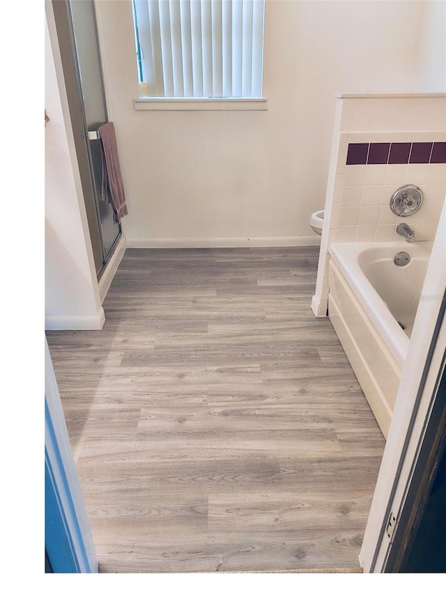 40533 E 8th Ave, Umatilla, FL 32784 - bathroom with a bath, wood finished floors, and a shower stall