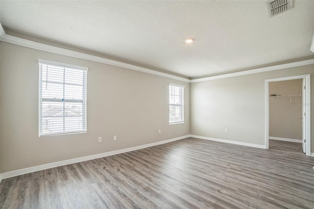 129 Eagleview Loop, Davenport, FL 33837 - unfurnished room featuring wood finished floors, crown molding, and a textured ceiling