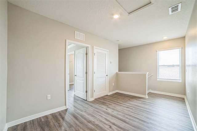 129 Eagleview Loop, Davenport, FL 33837 - unfurnished room with wood finished floors, attic access, and a textured ceiling