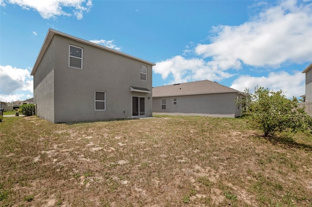 129 Eagleview Loop, Davenport, FL 33837 - back of property featuring a yard and stucco siding