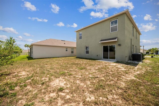 129 Eagleview Loop, Davenport, FL 33837 - rear view of property with stucco siding and a yard