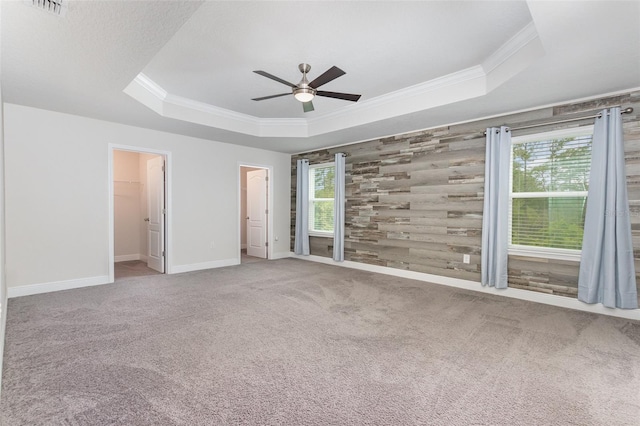 17044 Goldcrest Loop, Clermont, FL 34714 - unfurnished bedroom with a raised ceiling, ornamental molding, baseboards, carpet, and a walk in closet