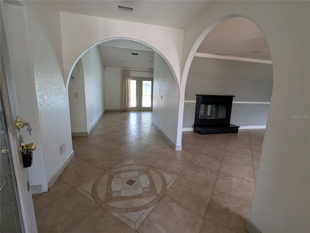 141 Angol St, Punta Gorda, FL 33983 - entrance foyer with baseboards, light tile patterned flooring, arched walkways, a glass covered fireplace, and crown molding