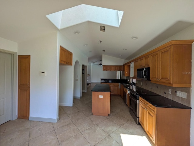 141 Angol St, Punta Gorda, FL 33983 - kitchen with a skylight, black microwave, vaulted ceiling, dark countertops, and a kitchen island