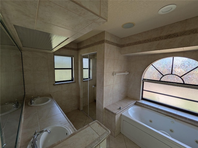 141 Angol St, Punta Gorda, FL 33983 - full bath with a tub with jets, tile walls, a tile shower, tile patterned flooring, and double vanity