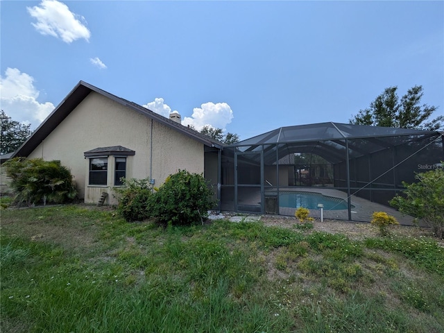 141 Angol St, Punta Gorda, FL 33983 - back of property with stucco siding, an outdoor pool, and a lanai