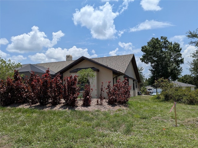 141 Angol St, Punta Gorda, FL 33983 - view of property exterior featuring a chimney, a yard, stucco siding, and a shingled roof