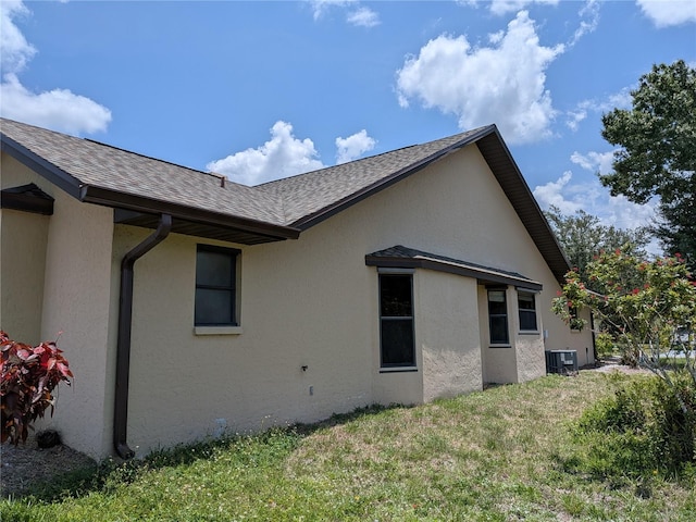 141 Angol St, Punta Gorda, FL 33983 - view of home's exterior with central air condition unit, stucco siding, roof with shingles, and a yard