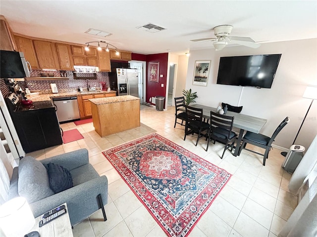 312 W Hull Ave, Oakland, FL 34760 - kitchen with appliances with stainless steel finishes, a sink, a center island, and light tile patterned flooring