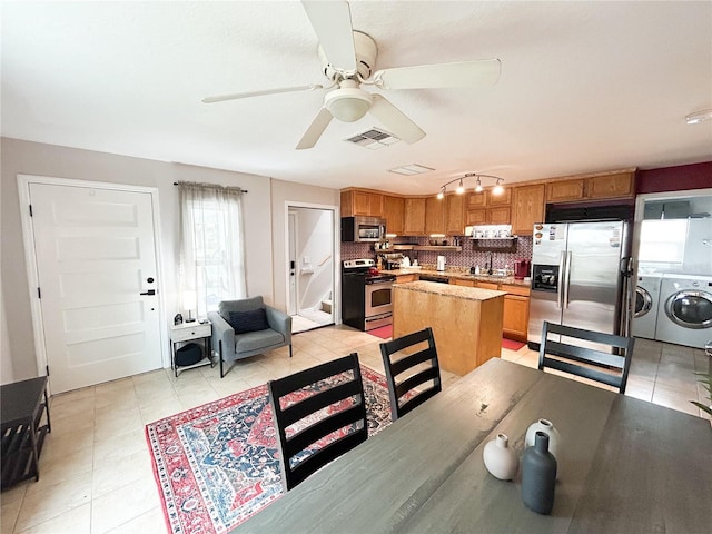 312 W Hull Ave, Oakland, FL 34760 - dining area featuring washing machine and clothes dryer, ceiling fan, and light tile patterned floors
