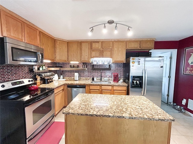 312 W Hull Ave, Oakland, FL 34760 - kitchen with stainless steel appliances, a sink, backsplash, light stone counters, and light tile patterned flooring