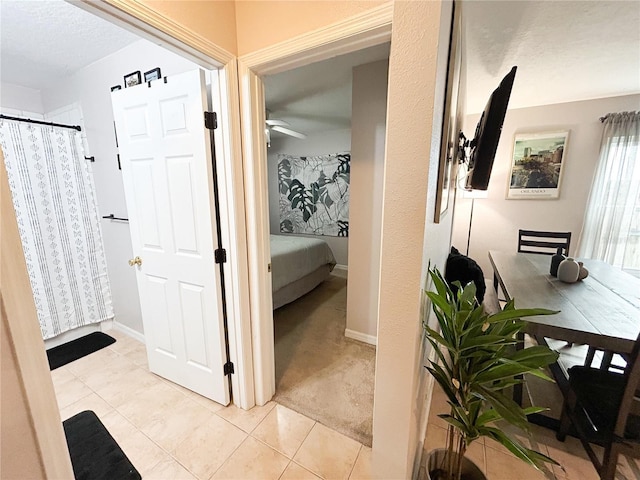 312 W Hull Ave, Oakland, FL 34760 - hallway featuring light tile patterned floors, light colored carpet, and baseboards