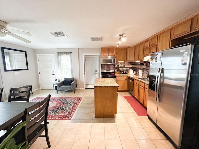 312 W Hull Ave, Oakland, FL 34760 - kitchen featuring stainless steel appliances, a kitchen island, ceiling fan, light tile patterned flooring, and tasteful backsplash