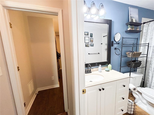 312 W Hull Ave, Oakland, FL 34760 - bathroom featuring vanity, toilet, and wood finished floors