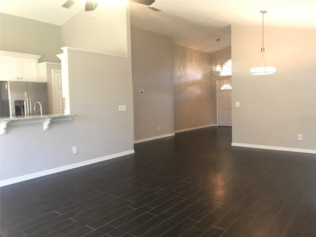 10969 Norcross Cir, Orlando, FL 32825 - unfurnished living room with high vaulted ceiling, dark wood-style flooring, baseboards, ceiling fan, and a sink