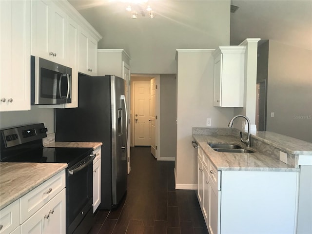 10969 Norcross Cir, Orlando, FL 32825 - kitchen featuring stainless steel microwave, electric range, a sink, a peninsula, and white cabinets