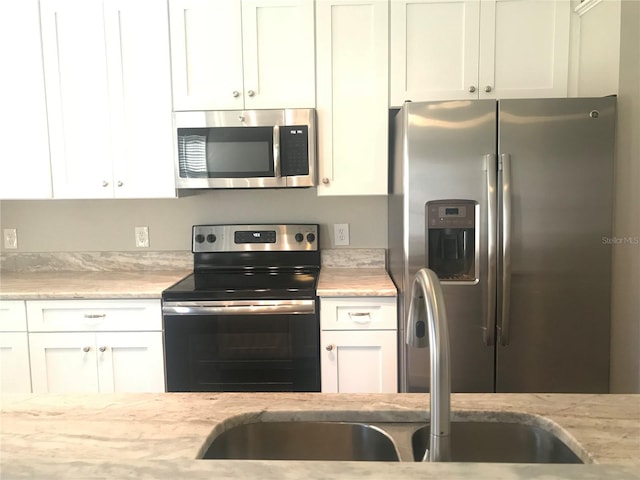 10969 Norcross Cir, Orlando, FL 32825 - kitchen featuring stainless steel appliances, white cabinets, and light stone countertops