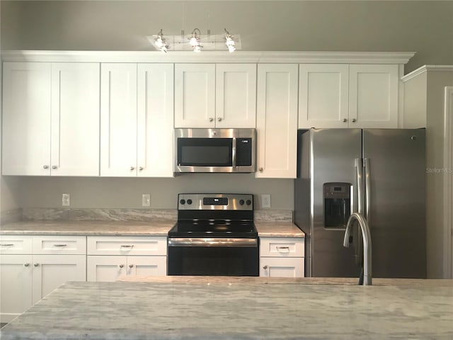 10969 Norcross Cir, Orlando, FL 32825 - kitchen featuring appliances with stainless steel finishes, white cabinetry, and light stone countertops