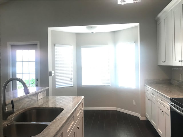 10969 Norcross Cir, Orlando, FL 32825 - kitchen featuring a sink, light stone countertops, baseboards, and white cabinetry