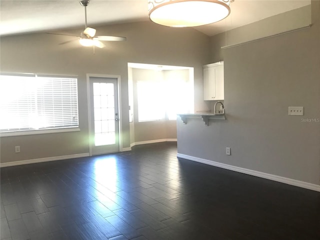 10969 Norcross Cir, Orlando, FL 32825 - unfurnished living room featuring ceiling fan, vaulted ceiling, baseboards, and dark wood-type flooring